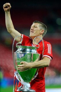 Bastian Schweinsteiger cheering jubilantly while holding the trophy