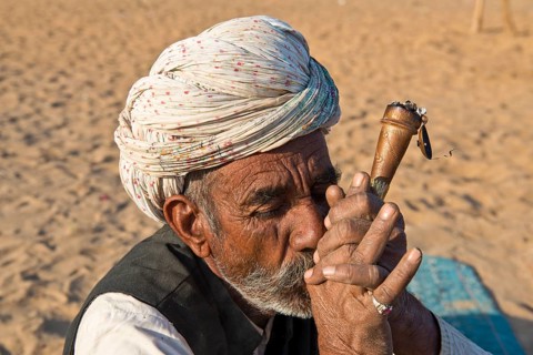 Indian man with a turban smoking a hash pipe