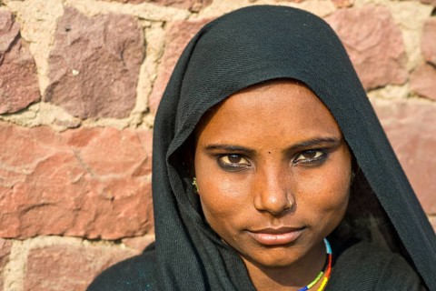 Young Indian woman wearing a black head scarf and a nose ring
