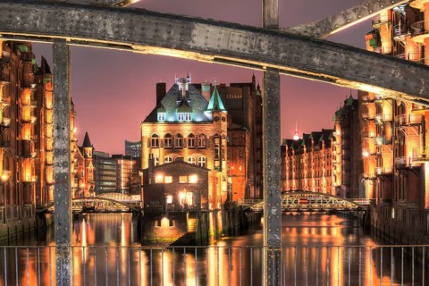 View through Poggenmuehlenbruecke bridge towards Wasserschloesschen water castle at night