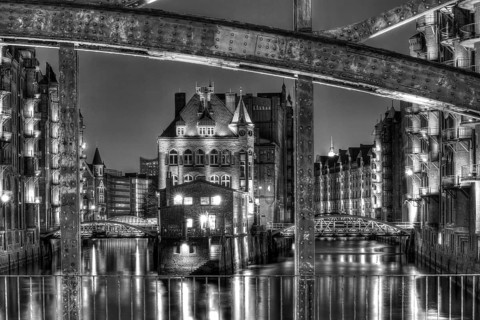 View through Poggenmuehlenbruecke bridge towards Wasserschloesschen water castle at night