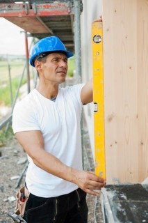Construction manager controlling the window installation with a spirit level