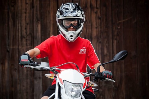 Boy wearing a helmet sitting on a motorcycle