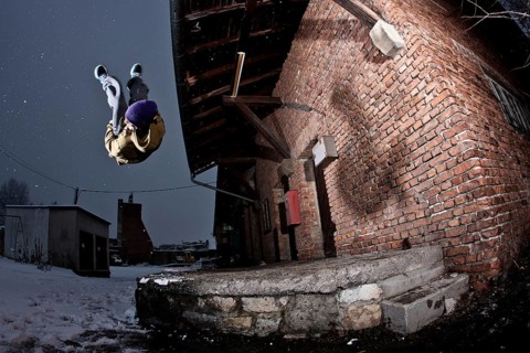 Freerunner doing a somersault at an old industrial site