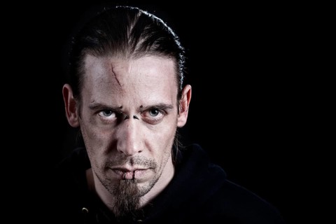 Man with piercings and a scar on his forehead