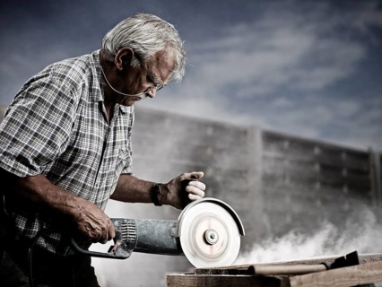 Stonemason cutting a stone slab with an angle grinder with a cutting disc