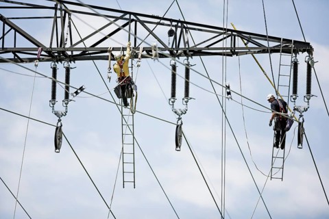 High-voltage service technicians installing a new high voltage power line