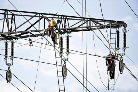 High-voltage service technicians installing a new high voltage power line
