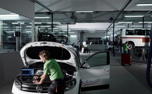 Car mechanic running fault diagnostics on a laptop