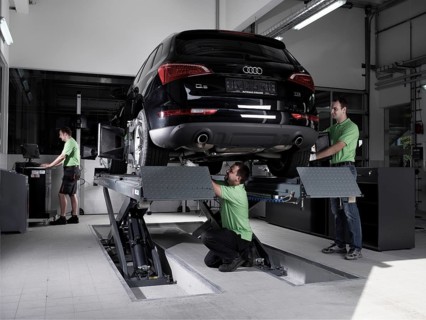 Workers assembling panels to track wheel alignments