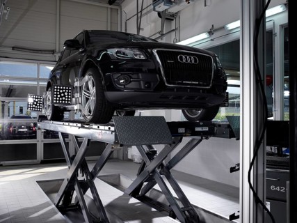 Car on a hoist with fitted pressure test panels for the wheel alignment
