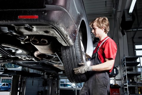 Car mechanic changing tyres in a car repair shop
