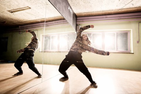 Breakdancer dancing in front of a mirror wall