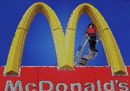 Worker repairing a Golden Arches sign