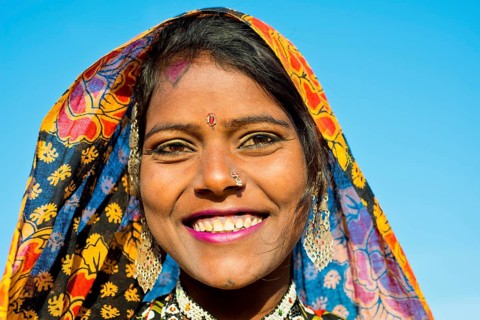 Smiling young woman with a colourful scarf and jewellery