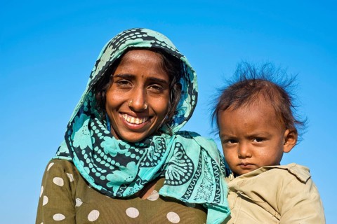 Indian woman with headscarf holding a little boy in her arms