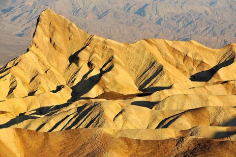 View from Zabriskie Point over the eroded rock formations of Manly Beacon discoloured by minerals