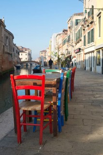 Colourful chairs of a street cafe on the Rio de la Misericordia