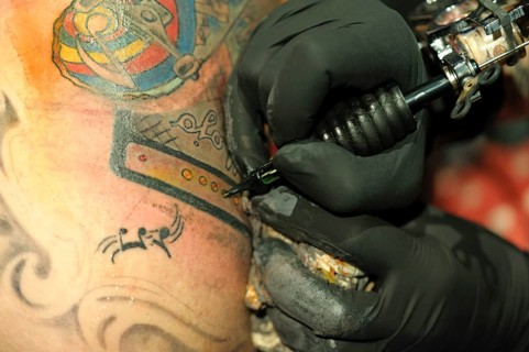 A young man is getting a tattoo