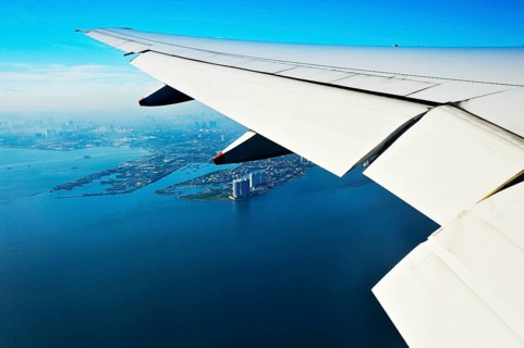 Wing of a plane and views of the port area of ??Jakarta on landing approach