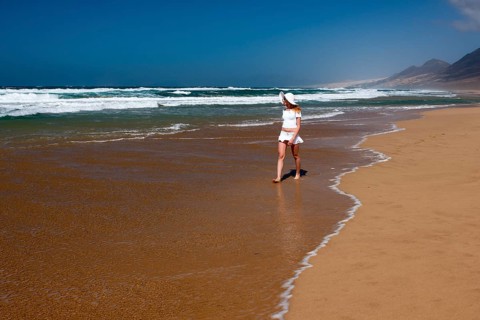 Woman walking along a sandy beach