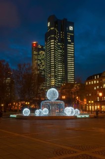 Illuminated Lucae Fountain on Opernplatz square in front of Trianon high-rise building and the Deutsche Bank Twin Towers