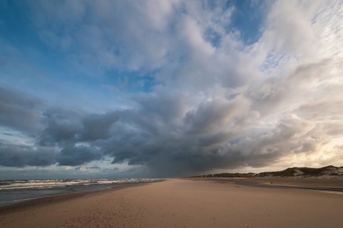 Dramatic cloud formation with rain showers over a North Sea beach