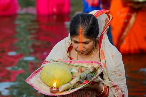 Woman wearing a sari with offerings during the Hindu Chhath Festival