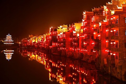 Red illuminated houses on the Wuyang River at night