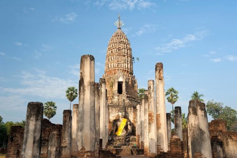 Seated Buddha statue in front of a chedi