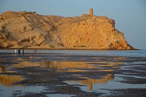 The rocky coast in Al Sawadi at the Gulf of Oman with a tower