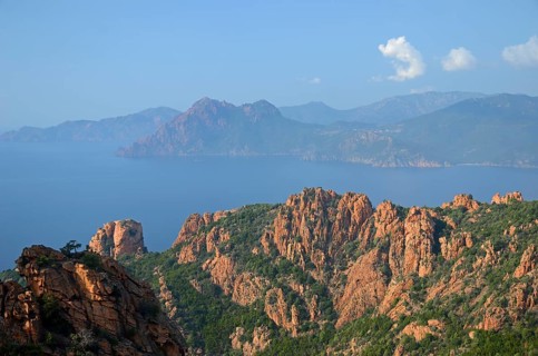 The typical bizarre red rocks of the Calanche of Piana and the mediterranean sea at the Gulf of Porto in the background. The Calanche of Piana is in the western part of the island Corsica