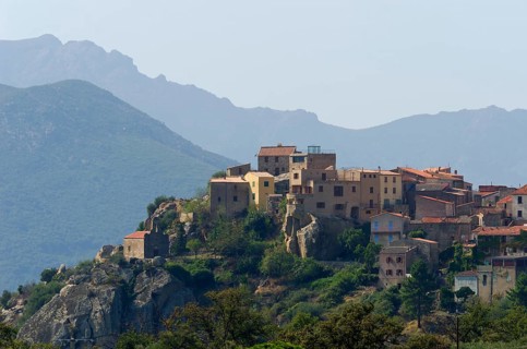 The small village of Montegrosso in front of the steep mountains of Corsica