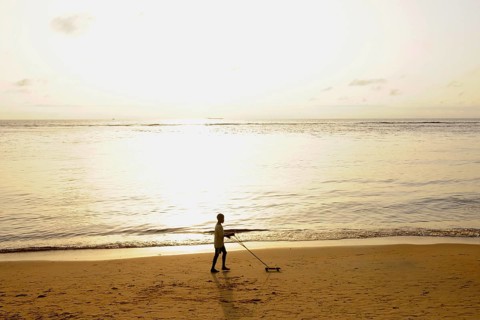 Boy playing on Kribi beach with a homemade toy