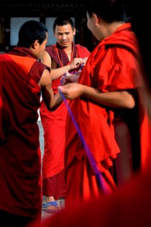 Buddhist monks producing textile trimmings