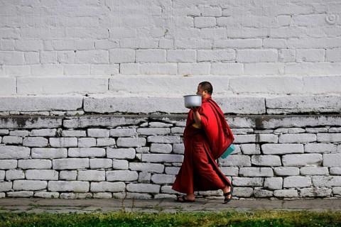 Monk walking through the monastery courtyard in Jampey Lhakhang Temple