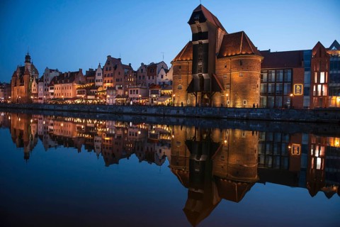Crane Gate or Brama Zuraw in the historic row of houses at dusk