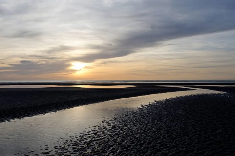Sunset over a beach at low tide
