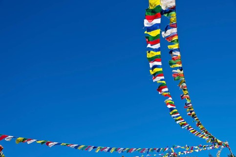 Buddhist prayer flags in front of blue sky above Namche Bazar (3.440 m)