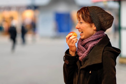 Smiling young woman eating an apple