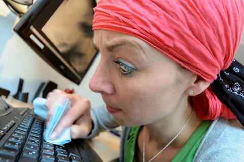 Cleaning lady cleaning a computer keyboard