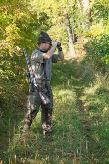 Hunter observing game with binoculars
