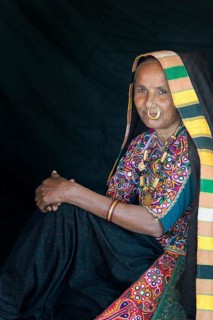 Elderly Ahir woman in traditional colorful clothes with a nose ring