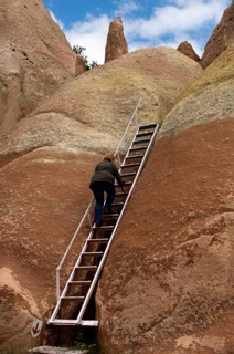 Visitor using a ladder on a hike through the tufa