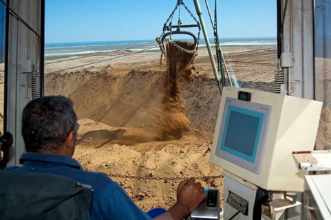 Excavator operator in the cab of a dragline excavator working in the diamond mine of De Beers Namaqualand Mines
