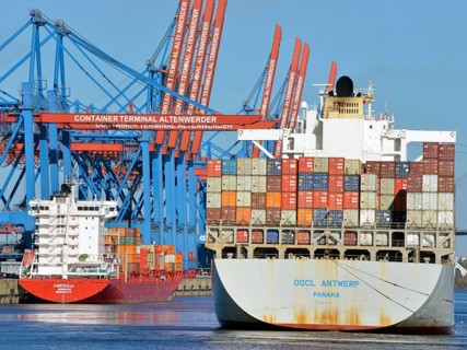 Container ship OOCL Antwerp with a feeder ship