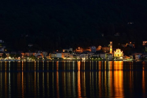 Village of Porto Ceresio with the Parish Church of Chiesa Sancto Ambrosio on Lake Lugano or Lago di Lugano at night