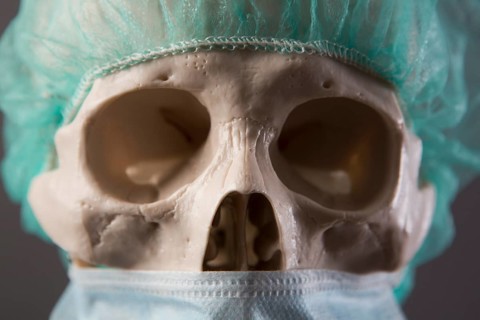 Skeleton dressed as a doctor with surgical mask and cap