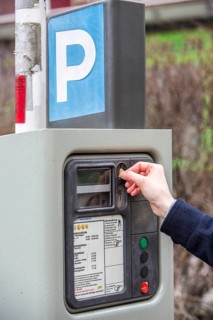 Woman purchasing a parking ticket from a parking ticket vending machine