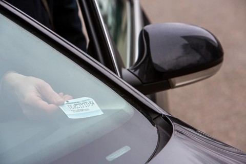 Woman placing a parking ticket in a visible location in her car
